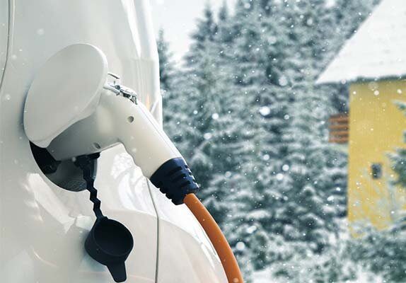 white electric car charging in the winter